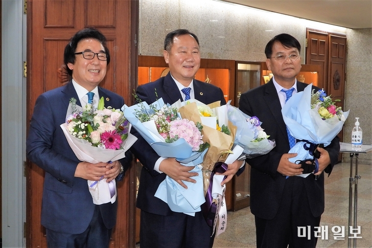 김인호 서울시의회 의장(가운데)와 김기덕 부의장(왼쪽), 김광수 부의장 당선자가 25일 오후 서울시의회 본회의장 앞에서 언론 인터뷰에 앞서 축하의 꽃다발을 받고 있다./사진=장건섭 기자