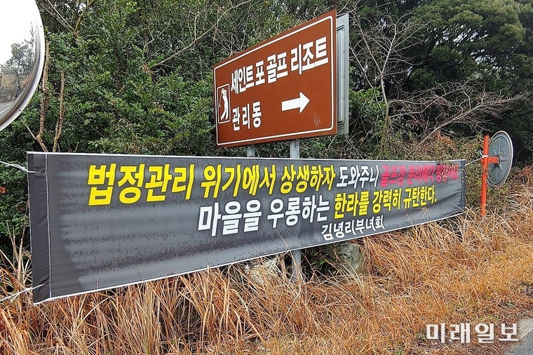 제주시 구좌읍 김녕리에 위치한 세인트포CC 입구에 김녕리부녀회가 한라건설을 규탄하는 현수막이 걸려있다./사진=인터넷언론인연대