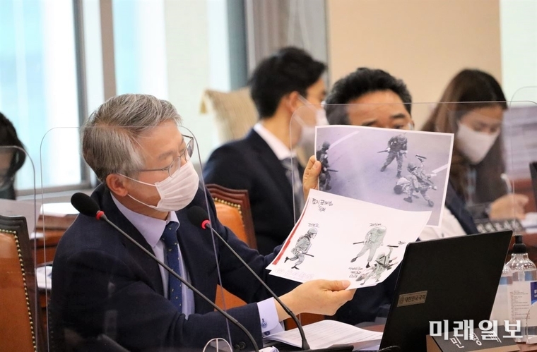 민형배 더불어민주당 의원이 22일 서울 여의도 국회에서 열린 열린 국회 정무위원회 제1법안심사소위원회에서 이남우 보훈처 차장에게 5.18민주화운동 당시 공수부대가 시민들을 폭행하는 사진과 문제가 된 신문 만평을 제시하며, 의견을 묻고 있다./사진=민형배 의원실