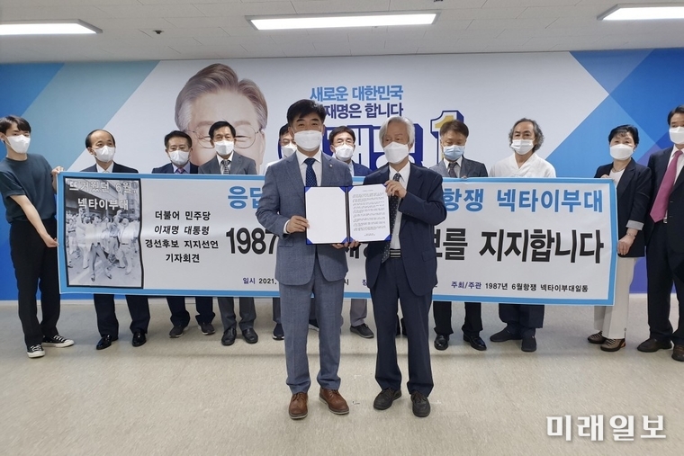 1987년 6월 민주항쟁을 이끌었던 '넥타이 부대' 1987인이 31일 오전 서울 여의도 이재명 캠프에서 열린 '넥타이부대 1987인 지지선언식'에서 참석자가 김병욱 이재명 캠프 직능총괄본부장(왼쪽)에게 더불어민주당 경선 후보 이재명 후보에 대한 공개 지지 선언문을 전달하고 있다./사진=이재명 열린캠프 제공