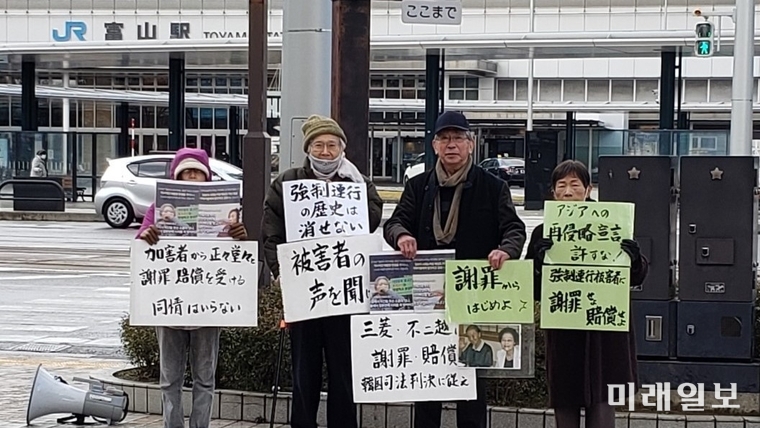 후지코시로 동원된 근로정신대 피해자들의 소송을 지원하는 '후지코시 강제연행 강제노동 소송을 지원하는 호쿠리쿠연락회' 무라야마 대표를 비롯한 회원들이 15일 일본 도야마시 도야마역 앞에서 비가 오는 가운데 한국 시민들과 연대해 선전활동을 펼치고 있다./사진=한일역사정의평화행동 제공