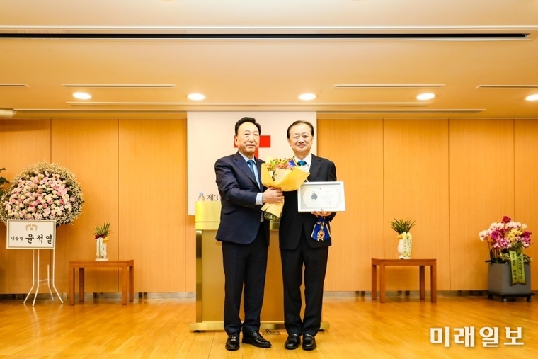김철수 신임 대한적십자사 회장(왼쪽)이 17일 서울 중구 대한적십자사 서울사무소에서 열린 대한적십자사 31대 회장 취임식에서 신희영 전임 회장에게 적십자 대장 태극장과 포장증을 수여한 뒤 기념촬영을 하고 있다./사진=대한적십자사 제공