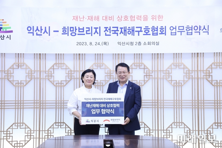 김정희 희망브리지 사무총장(왼쪽)이 24일 전북 익산시청에서 정헌율 익산시장과 '익산시-희망브리지 전국재해구호협회 재난재해 대비 상호협력 업무 협약식'을 개최하고 있다./사진=희망브리지 제공