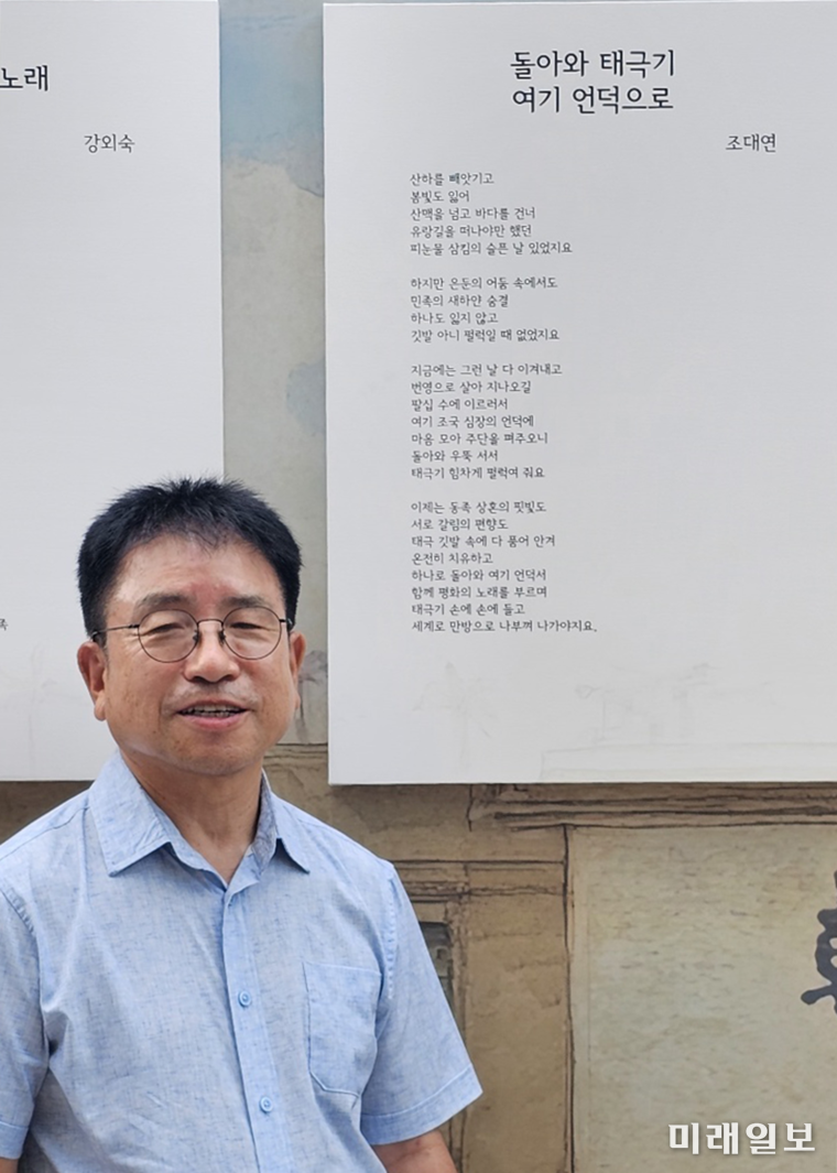 제80주년 광복절인 15일 오후 서울 중구 서울도서관 정문 앞에 설치된 '태극기 언덕'에 조대연 시인이 전시 작품 앞에서 기념촬영을 하고 있다./ⓒ미래일보