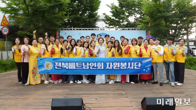 8월 31일 오후, 전북 전주시 완산구 고사동 오거리문화광장에서 개최된 전북베트남인회가 주최한 '2025 전북베트남문화의 날' 행사에서 전북베트남인회 자원봉사단 회원들이 행사를 마치고 기념촬영을 하고 있다./사진=장건섭 기자