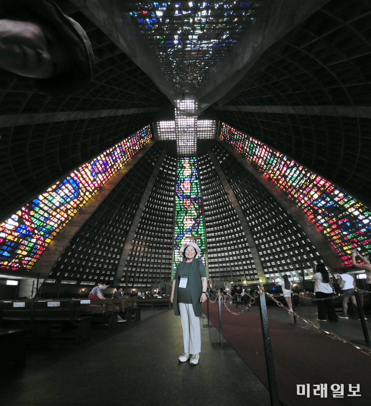 브라질 리우데자네이루 메트로폴리탄 대성당(Metropolitan Cathedral)’ 내부 스테인드글라스 앞에서 김민정 시인이 기념촬영을 하고 있다./사진=김민정 시인 제공