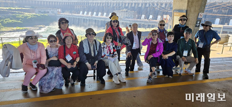 브라질과 파라과이 사이에 있는 파라나(Parana)강의 이타이푸 수력발전소(Itaipu Complex) 댐(파라과이, 브라질, 아르헨티나 합작)' 댐이 보이는 장소에서 해외 문학기행에 참석한 사단법인 한국문인협회 회원들이 기념촬영을 하고 있다./사진=김민정 시인 제공