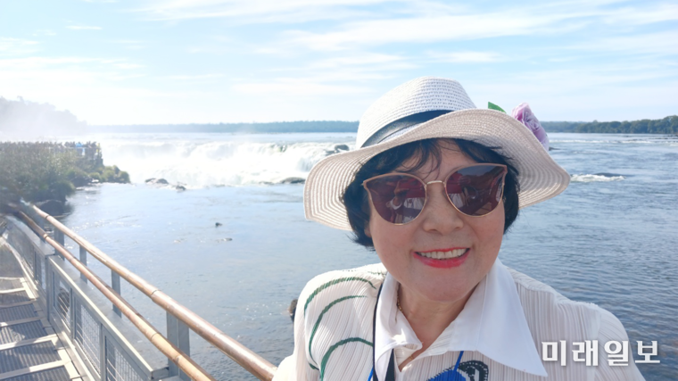 김민정 시인이 포말처럼 보이는 '악마의 목구멍' 앞에서 기념촬영을 하고 있다./사진=김민정 시인 제공