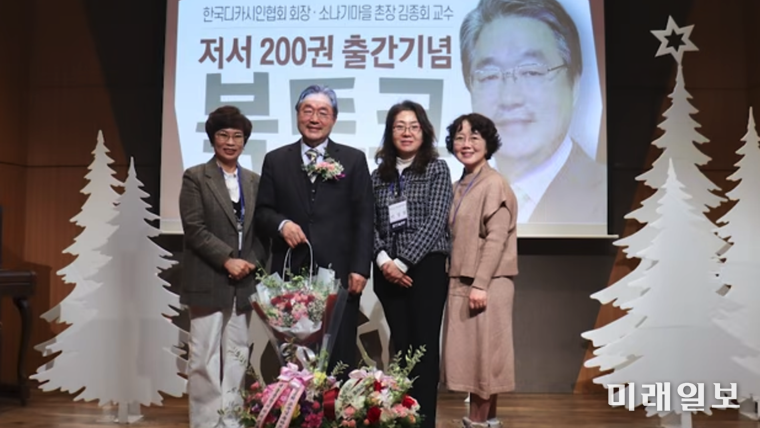 김종회 황순원문학촌 소나기마을 촌장(문학평론가)이 지난해 12월 26일, 황순원문학촌 소나기마을 수숫단강당에서 열린 '저서 200권 출간기념 북토크'에서 참석 인사로부터 축하 꽃바구니를 전달 받고 있다./사진=황순원문학촌 소나기마을 문학강연 채널 '문학마실' 제공