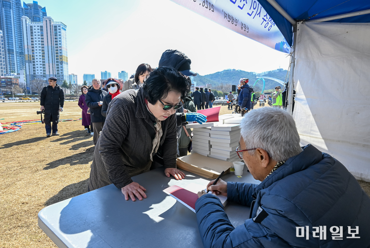 정성수 시인이 지난 3월 7일 오후 울산 태화강 국가정원 1둔치에서 개최된 신간 산문집 <인생 편지> 출간 기념 사인회를 진행하고 있다./ⓒ미래일보