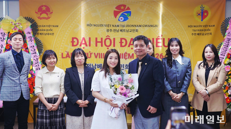 3월 29일 광주에서 열린 '광주·전남베트남교민회 제8차 대표자 대회(임기 2026~2028)'에서 주한 베트남 대사관 대표인 안 부 빈 2등 서기관이 웬티레화 회장에게 축하의 꽃다발을 수여하고 기념촬영을 하고 있다./사진=광주·전남베트남교민회 제공