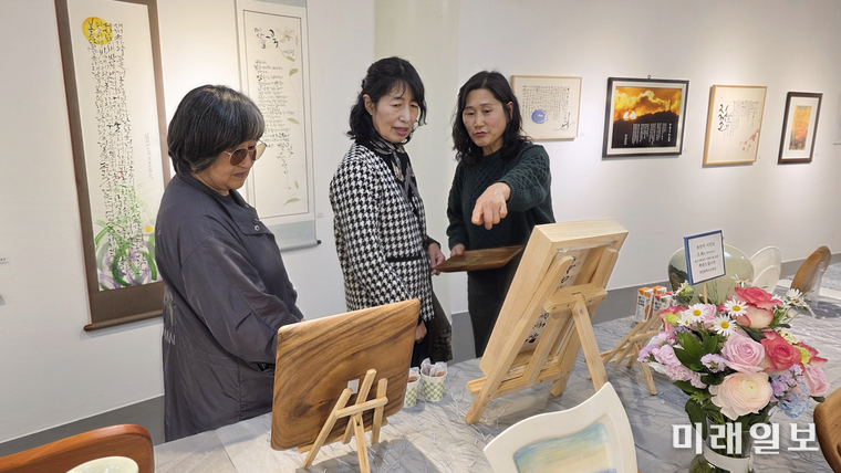 4월 7일 대전 중구 중앙로 대전예술가의 집 제2전시실에서 열리고 있는 2026 한국시화창작 시화담 展 <봄, 詩로 피어나다Ⅱ>'에서 참여 문인이 전시 작품을 관람하고 있다./사진=대전문총 제공